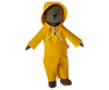 A toy bear, affectionately termed Teddy Dad, is dressed in the Maileg Extra Clothing: Rainwear for Teddy Dad—a charming ensemble featuring a yellow raincoat with a hood and matching yellow pants—as it stands upright.