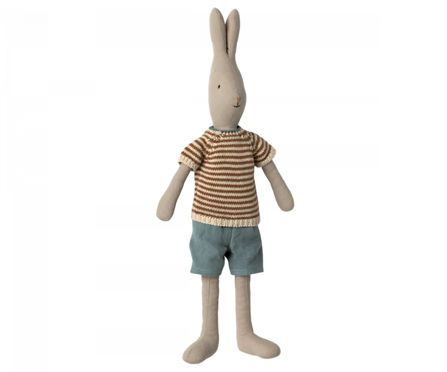 The Maileg Rabbit Size 3, Classic, stands upright as a charming bunny toy with long ears. This soft rabbit is made from natural linen and is dressed in a striped brown and white knit sweater along with teal shorts. Its minimalist facial features, including a small nose and eyes, add to its simple yet endearing look. Expand the wardrobe options available!