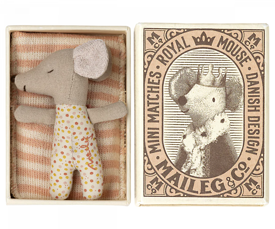 a small mouse doll inside a match box, sleeping with a blanket.