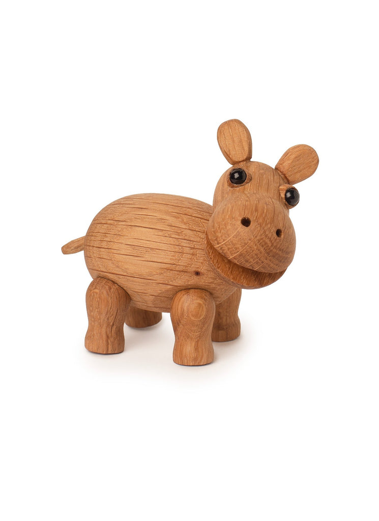 A small, carved wooden Spring Copenhagen Wilma calf figurine with a round body, short legs, large eyes, and small ears. The figure is made of light-colored wood with visible grain patterns and texture details. This charming piece of African decor stands on a white background.
