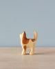 A Handmade Holzwald Cat figurine, crafted from high-quality wood, with a light tan body and brown patches, standing upright against a plain blue background.