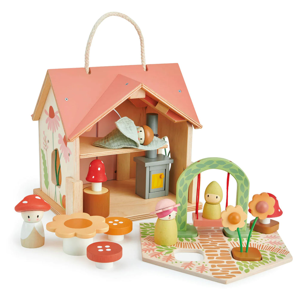 The Rosewood Cottage playset features a woodland cottage with a removable roof, miniature sleeping figure, stove, and kitchenette. It includes mushroom figurines, flowers, and a swing set for an enchanting meadow vibe.