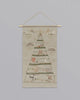 Coral & Tusk Embroidered Advent Calendar wall hanging featuring a countdown to Christmas design with animal motifs, suspended from a wooden dowel against a plain background.