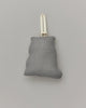 A small, gray Coral & Tusk Ice Skater Bears Ornament with a white ribbon loop at the top, centered against a plain light gray background. The ornament appears to be softly padded and has a simple, clean design, perfect for displaying on a tree during the holidays.