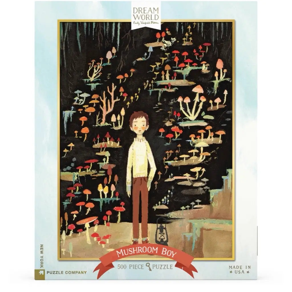 An illustration of a boy standing in a forest with various colorful mushrooms around him on an "Emily Winfield Martin, Mushroom Boy Puzzle - 500 Piece" jigsaw puzzle box by Dream World Puzzle Company.